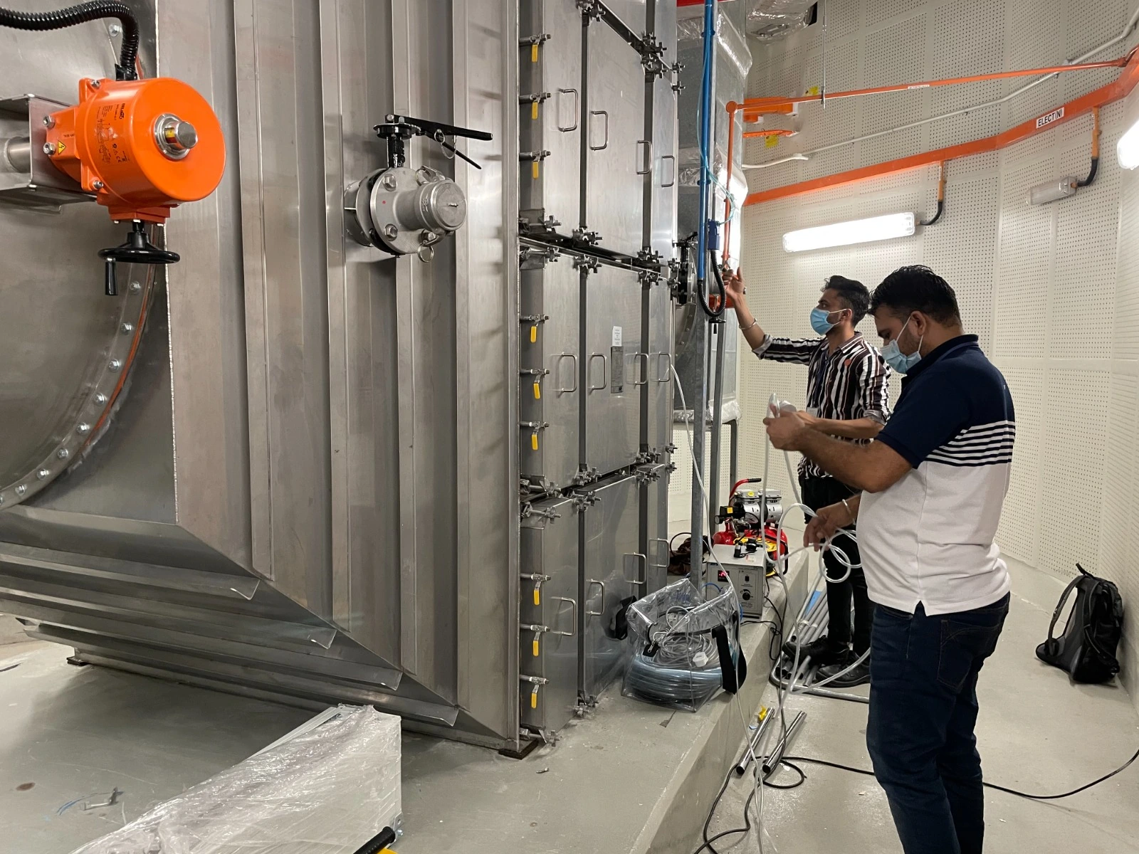 Technicians inspecting industrial clean air filtration equipment