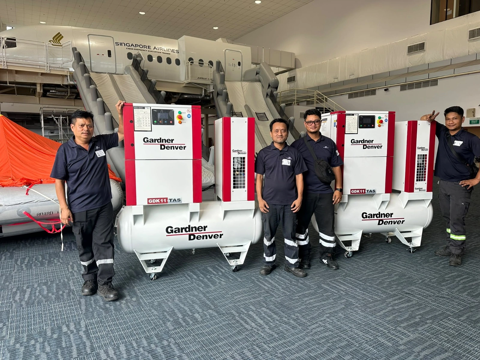 Four INNEOVA team members with Gardner Denver compressors