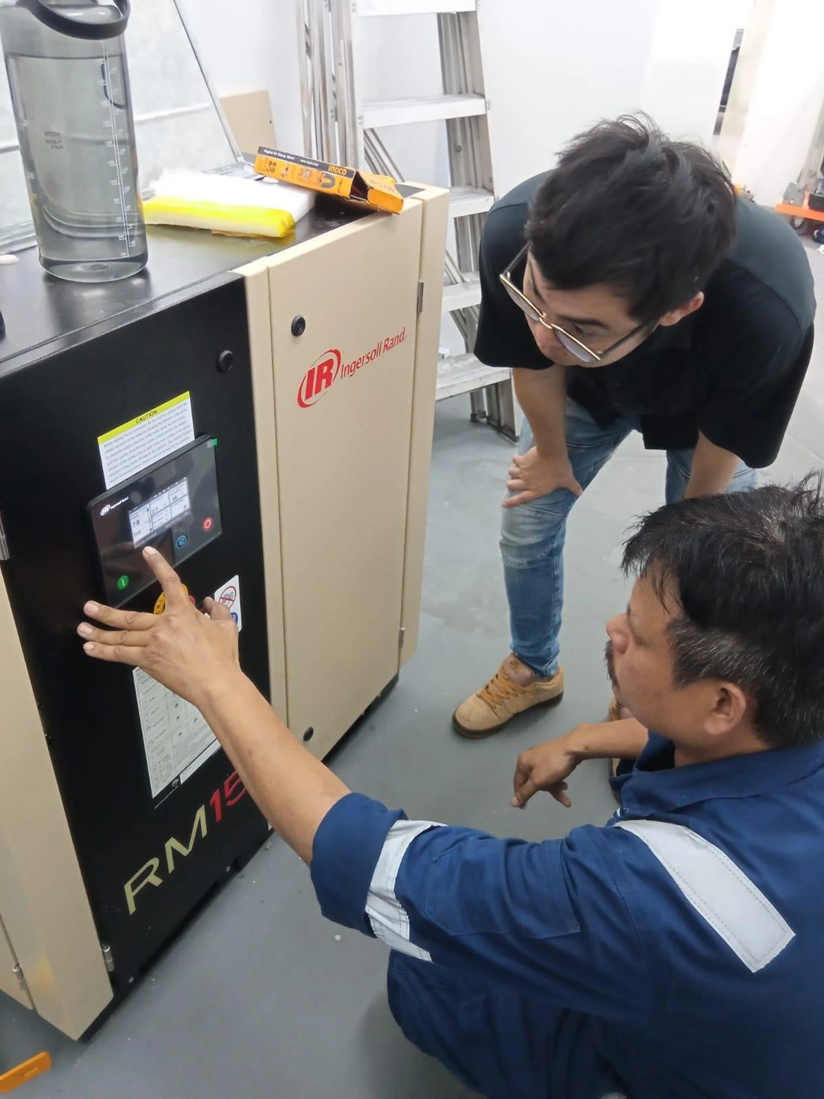INNEOVA team checking the controls of an Ingersoll Rand compressor