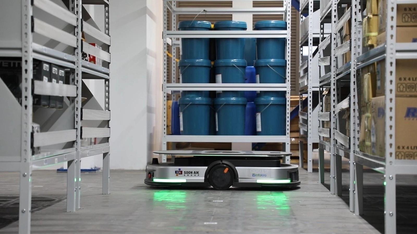 Autonomous mobile robot transporting a rack of drums in a warehouse